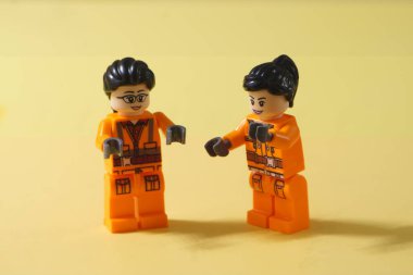 1 Mayıs 2024, Ibi, İspanya. Kentsel temizlik, çöp toplama ya da dinlenme zamanlarında rahatça konuşan iki kadın. İkisi de sarı arka planda turuncu üniforma giyiyor. Kavram