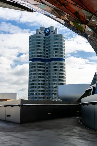 17 Mart 2024 - Münih, Almanya. BMW MUSEUM 'un ön yüzü BMW dünyasından görüldü. Hayır İnsanlar, dikey çekim, turizm, güneşli gün, bulutlar, mavi gökyüzü