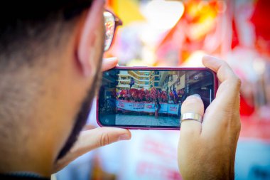 Alicante, Spain - September 26th 2024. Workers demonstration for labour rights are taken a picture using a mobile phone clipart