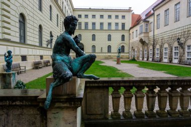 18 Mart 2024 - Münih, Almanya. Münih 'in orta kesimindeki Munchner Malikanesi' nin girişindeki mutlu bir faun heykeli, Bavyera 'nın Wittelsbach hükümdarlarının eski kraliyet sarayıdır. Heykel