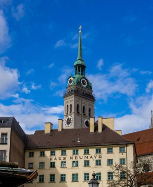 16 Mart 2024 - Münih, Almanya. St. Peter, Peterskirche Kilisesi 'nin önündeki Haus Neumayr Evi, diğer adıyla Alter Peter. Viktualienmark 'tan görüntüle. Dikey seyahat günlük fotoğrafı