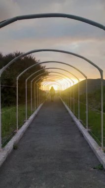 The Girl Goes through the Esttunel to the Sea Against the Sunset or dawn, a Natural Background. Kadın yalnız seyahat eder. Günbatımında Doğadaki Genç Kız. Aktif Yaşam Tarzı, Turist Yürüyüşü.