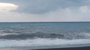 Okyanus Dalgaları. Okyanus Dalgaları ile yüzmek, Güneş tarafından aydınlatılan bir kameraya doğru bir deniz suyuna çarpan kıvrımlı bir rulonun yakın çekimine çarpar..