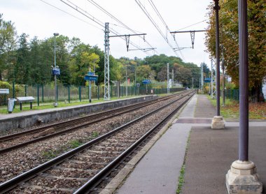 Paris 'in banliyölerindeki istasyonda demiryolu trenleri. İş gezileri. Yoldaki yolcular.