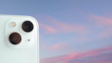 Telefon kamerası. Zaman atlamalı Gökyüzü Arkaplanına Karşı Kameranın Yakın Çekimi. Doğa, Seyahat ve Hayatın Bir Bütünleşik Parçası İçin Telefon.