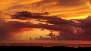 Bulutlu dramatik gün batımı. Şehir ve Sahil Hattı Silueti Kırmızı ve Turuncu Gökyüzü Altında Fantastik Günbatımı Gökyüzü, Dalgaları Yakalayan, Rahatlatan, Eğlenceli Dramatik Seyahat, Akşam Doğası.