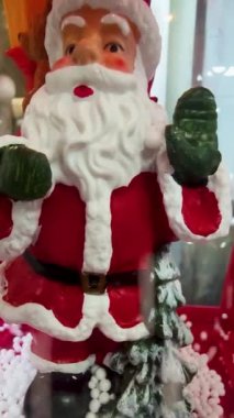 Düşen Kar Arkaplanındaki Noel Baba hatırası. Noel Baba, Noel için çocuklara bir hediye. Mutluluk ve Arzuların Tatmini kavramı. Kış Tatili Arkaplanı.