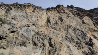 Deniz kıyısında Kuş Yuvalı Yüksek Taş Duvar. İtalya, Calabria 'da Kırlangıç Yuvaları Doğal Taş Altında.