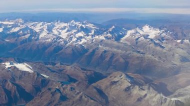 Dağın Havadan Mükemmel Çekimi. Mavi Gök 'ün altında, virajlı yol ve göllerle karlı dağ manzarası. 4K