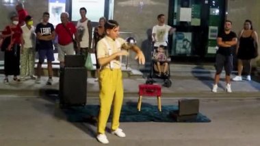 Diamante, İtalya, 25 Kasım 2022: Dost canlısı sihirbaz bir gösteri sergilemeye, dans etmeye ve sokakta insanları eğlendirmeye odaklanıyor. Erkekler Calabria, İtalya 'da düzenlenen bir festivalde balonlarla, hokkabazlıklarla ve şakalarla numaralar yapıyorlar..