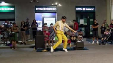 Diamante, İtalya, 25 Kasım 2022: Dost canlısı sihirbaz bir gösteri sergilemeye, dans etmeye ve sokakta insanları eğlendirmeye odaklanıyor. Erkekler Calabria, İtalya 'da düzenlenen bir festivalde balonlarla, hokkabazlıklarla ve şakalarla numaralar yapıyorlar..