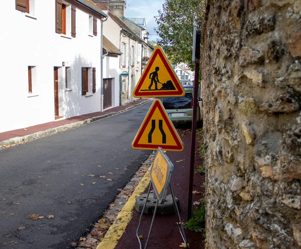 Under Construction Board Sign on the Closed Road with Arrow sign. Caution Symbol Under Construction in the Street in Ville de Jouy en Josas, France.