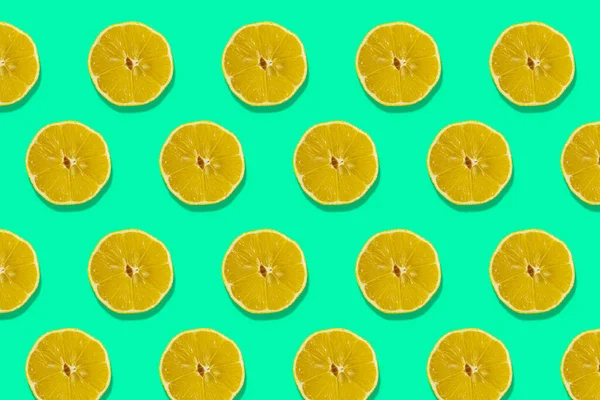 Fruity Pattern of Fresh Citrus Slices on a Green Background. View From Above.