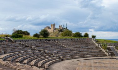 Arena 'nın iç kesiminin panoraması. Diamante, Cirella, İtalya 'daki Stone Amfi Tiyatrosu Kalenin Arkaplanına Karşı. Yuvarlak Eski Taş Amfi Tiyatrosu. 