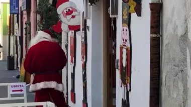 Noel arifesinde yaşlı sakallı Noel Baba, İtalya 'da küçük bir kasabanın merkezinde duruyor. Mutlu Noeller, Dünya Barışı.