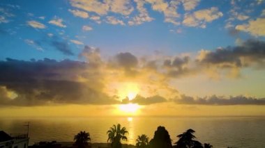 Güneşli Deniz 'in fantastik hava manzarası. Şatafatlı bir Gökyüzünün Arkaplanına Karşı Palmiye Ağaçlarının Siluetleri. Sahilde romantik bir akşam yemeği. Palm Trees 'in altındaki sahilde romantik günbatımı.