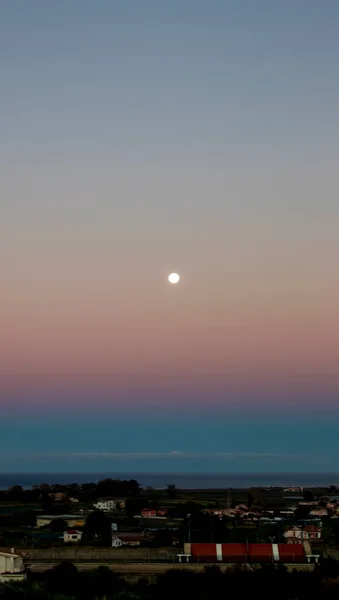 Beautiful Pink and Purple Full Moon Rise at Sunset. Early Morning Dawn Twilight with Moon.