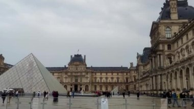 Paris, Fransa, 3 Ocak 2023 Louvre Meydanı. Piramitler, Çeşme. Turistler meydanda yürür. Sonbahar Yağmurlu Günü.