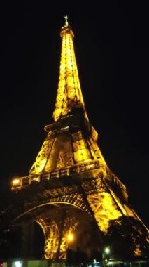 Gece Eyfel Kulesi. Bu tarihi anıt, Fransa 'nın başkenti Paris' in kalbinde, caddenin üzerinde yükseliyor..