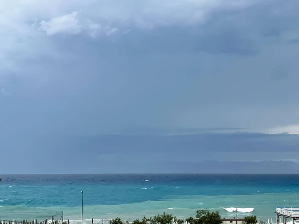 Cloudy Storm in the Sea Before the Rain. Tornado Raging Cloud Over the Sea. Dark Sky Over Turquoise Ocean Water.