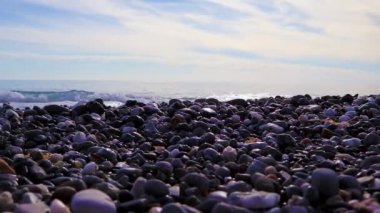 Sea Polished Rocks Close-up. Sea Waves Crash Onto a Pebble Beach.
