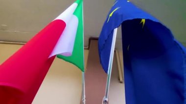 The Flags of Italy and the European Union Flutter in the Wind on a Sunny Day. Democracy and Politics. European Country.