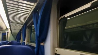 Interior of a Modern Train at Night with Blue Curtains and Seats. Travel and Tourism Concept. Amazing Cinematic Shot.