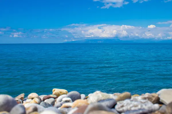 海岸線 前景にペブルビーチとクリスタル水 ブリュリー背景と前景と海に中央の焦点 夏休み海の近く — ストック写真