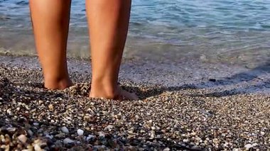 Deniz Dalgalarıyla Sahilde Altın Kum Üzerinde Kadın Ayakları 'nı kapatın. Seyahat, Turizm, Seyahat, Rahatlama Konsepti.