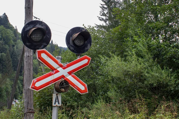 Train Crossing. Stop Sign Attention Railway Tracks with a Small Station Outside the City Outside the Village.