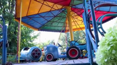 Küçük şirin kız lunaparkta atlıkarıncaya biniyor..