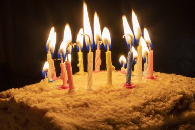 Doğum günü pastasında yanan mumlar var. Mumlu doğum günü pastası. Dilekler gerçek olur..