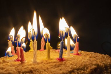 Doğum günü pastasında yanan mumlar var. Mumlu doğum günü pastası. Dilekler gerçek olur..