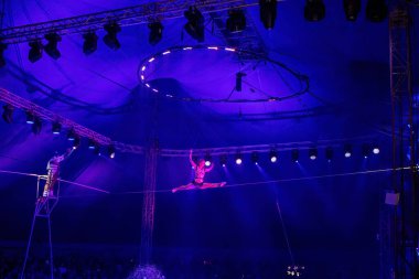 Münih, Almanya, 13 Aralık 2023: Sirk akrobatları iplerle gösteri yapıyorlar. Bir kız havada akrobatik hareketler sergiliyor..