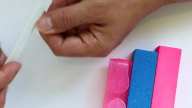 Kadın eli, yakın plan. Manikür, beyaz arka plan tırnak törpüsü, ev manikürü, tırnak bakımı..