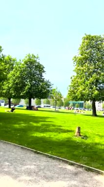 Münih, Almanya, 20 Nisan 2024: Kadınlar ve erkekler Alte Pinakothek Müzesi, Münih, Bavyera, Almanya yakınlarındaki çimenlikte dinleniyorlar.