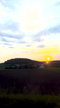 Tren penceresinden Alpler 'in üzerine şafak söktü. Almanya 'da Münih yakınlarında bir otoyolda gün batımı. Dağların tepeleri Alpler 'deki bir tren penceresinin manzarasına hakimdir..