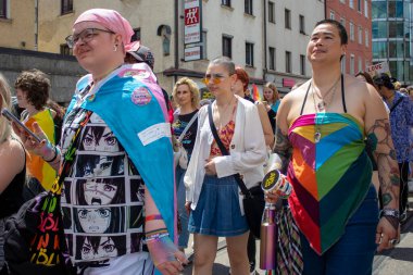 Münih, Almanya, 22 Haziran 2024: Onur Yürüyüşü. Holi festivali. Gökkuşağı ve diğer teçhizatlarla gösteriyi bekleyen parlak ve mutlu katılımcılar. 