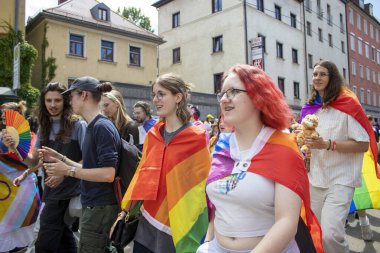 Münih, Almanya, 22 Haziran 2024: Onur Yürüyüşü. Gökkuşağı ve diğer teçhizatlarla Münih 'teki gösteriyi bekleyen parlak ve mutlu katılımcılar. 