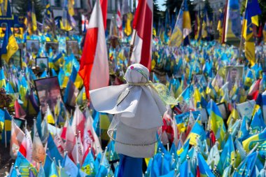 Rus-Ukrayna savaşında ölen askerlerin anısına Ukrayna 'nın sarı-mavi bayraklarına karşı Motanka bebeği. Savaş yok..