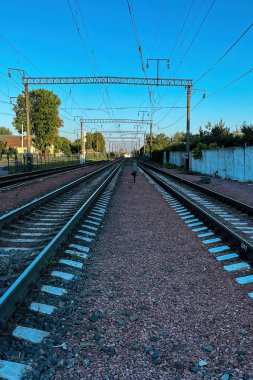 Demiryolu rayları. Karanlık yaz gökyüzü yaklaşırken tren yolları ufka doğru çekiliyor..