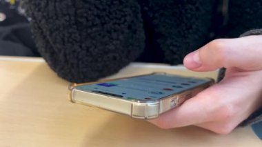 Sıradan bir ortamda Masa 'da Otururken Sosyal Medya Güncellemelerini Denetlemek için Akıllı Telefon Kullananlar