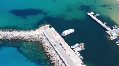 Tekneleri ve berrak mavi suları olan Serene Limanı 'nın dramatik hava görüntüsü