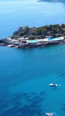 Akdeniz 'de berrak mavi su ve tekneleri olan gözlerden uzak bir adanın güzel kıyı manzarası