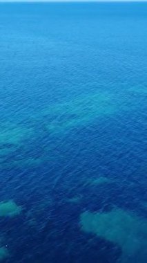 Parlak Mavi Okyanus Manzarası Yumuşak Dalgalar ve Güneş Işığıyla Sakin Sahil Ortamı Yüzeyine Yansıyan