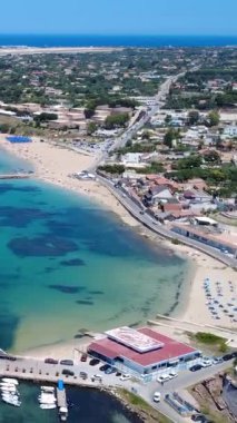 Güneşli bir günde Berrak Mavi Suları ve Kumsalı olan bir sahil kasabasının çarpıcı hava manzarası