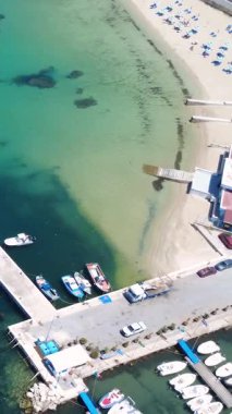 Berrak suları ve tekneleri Kıyı Kasabası 'nda güneşli gökyüzünün altına yanaşmış canlı bir sahil.