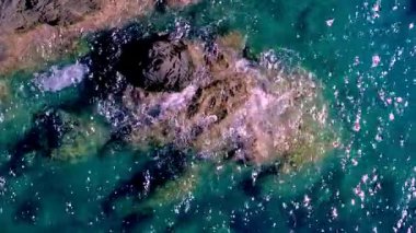 Kıyı bölgesinde güneşli bir günde açık mavi suyla Rocky Kıyı Şeridi 'nin büyüleyici görüntüsü