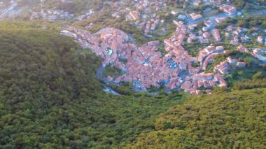 Günbatımında manzaraya bakan devasa bir heykel manzarası ziyaretçilerle birlikte çevreyi keşfediyor. Maratea, Basilicata, İtalya