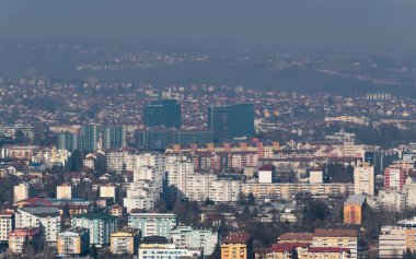 Güneşli bir günde Banja Luka 'nın şehir manzarası sisli ve kirli havada kayboluyor